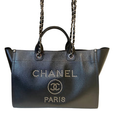 Chanel Deauville tote bag in black grained calfskin featuring silver metal studded CHANEL PARIS logo and CC emblem